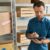 Man checking inventory in a stock room with a mobile device