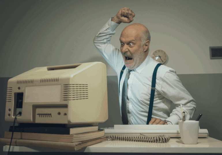 Legacy IT Older office worker angry with ageing computer