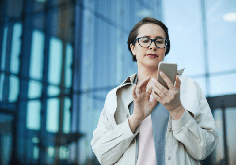 business woman on smartphone outside office building