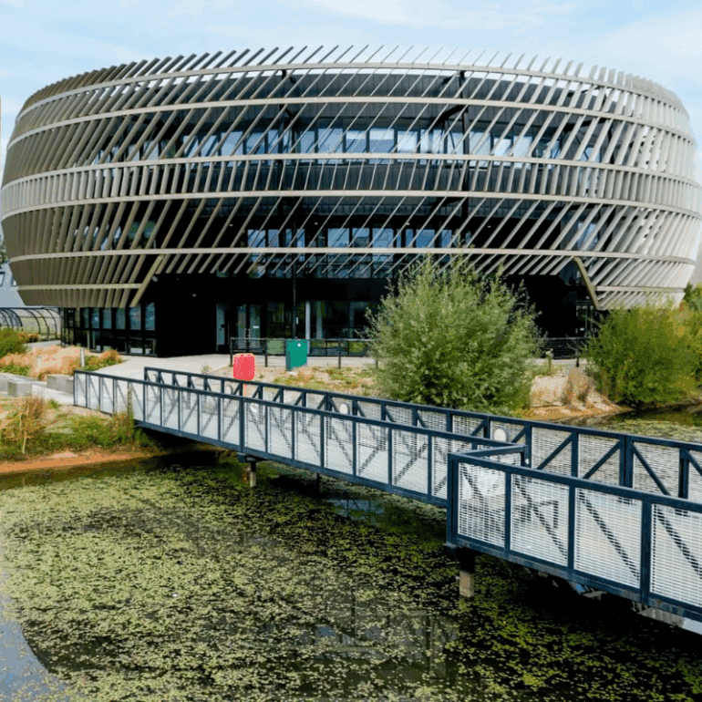 unip with bridge in foreground Modern office building with innovative architectural design and surrounding landscaping, showcasing advanced corporate infrastructure.