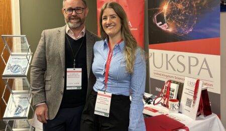 Two members of Modern Networks event team in front of the company's stand at an UKSPA conference