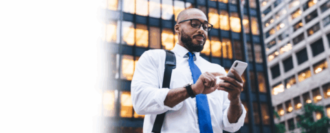  Office worker looking at a white smartphone with office buildings in the background